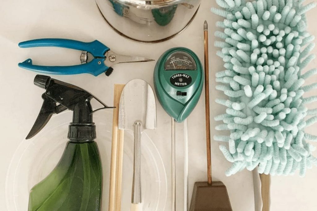 Indoor plant care tools: spray bottle, moisture meter, trowel, pruners, watering can