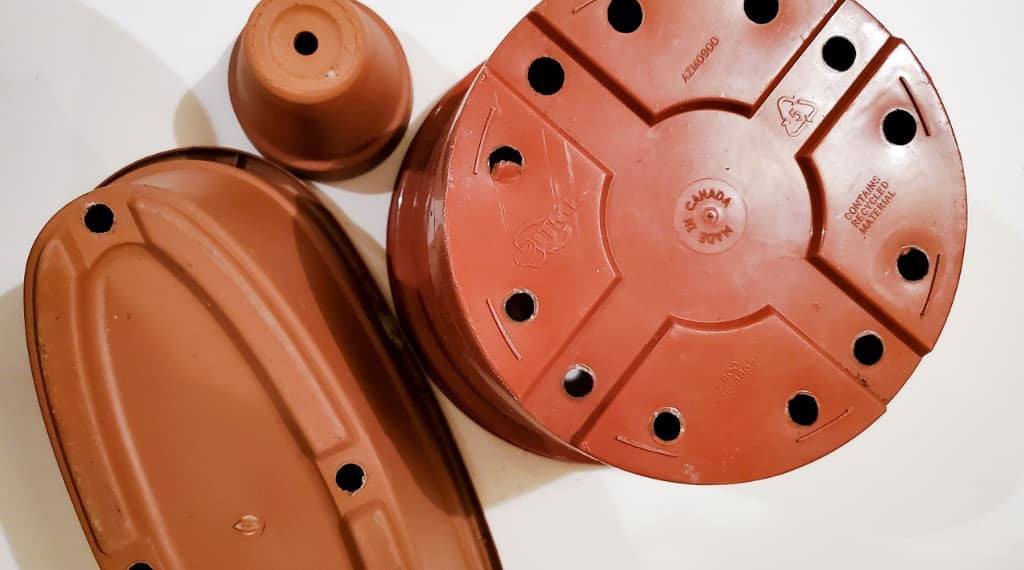 group of plastic and terracotta plant pots with drain holes
